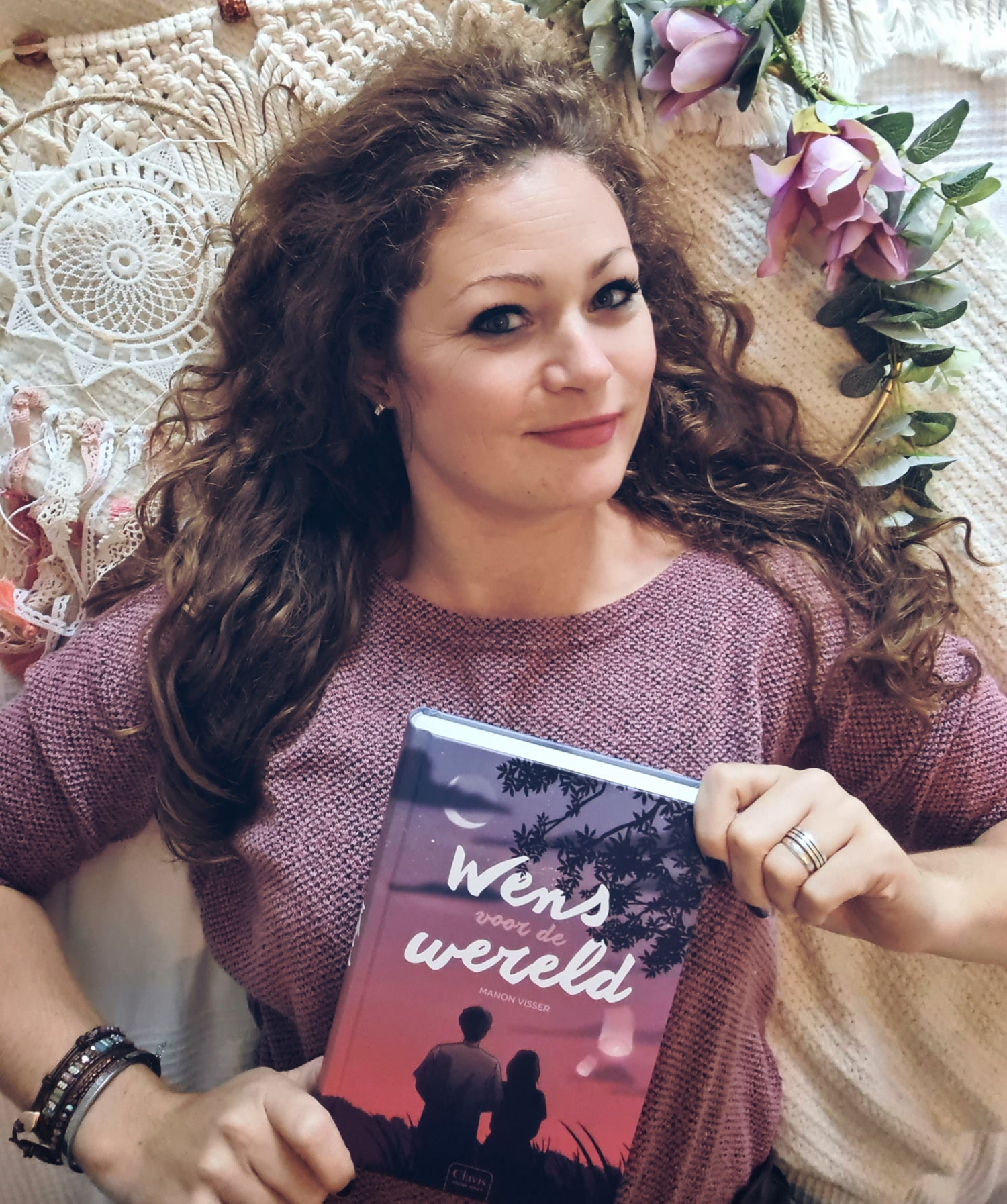 boekenliefhebber met een boek met de titel wens voor de wereld in haar handen